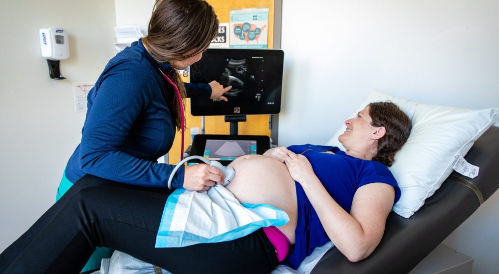 Physician conducting an ultrasound on a pregnant patient.